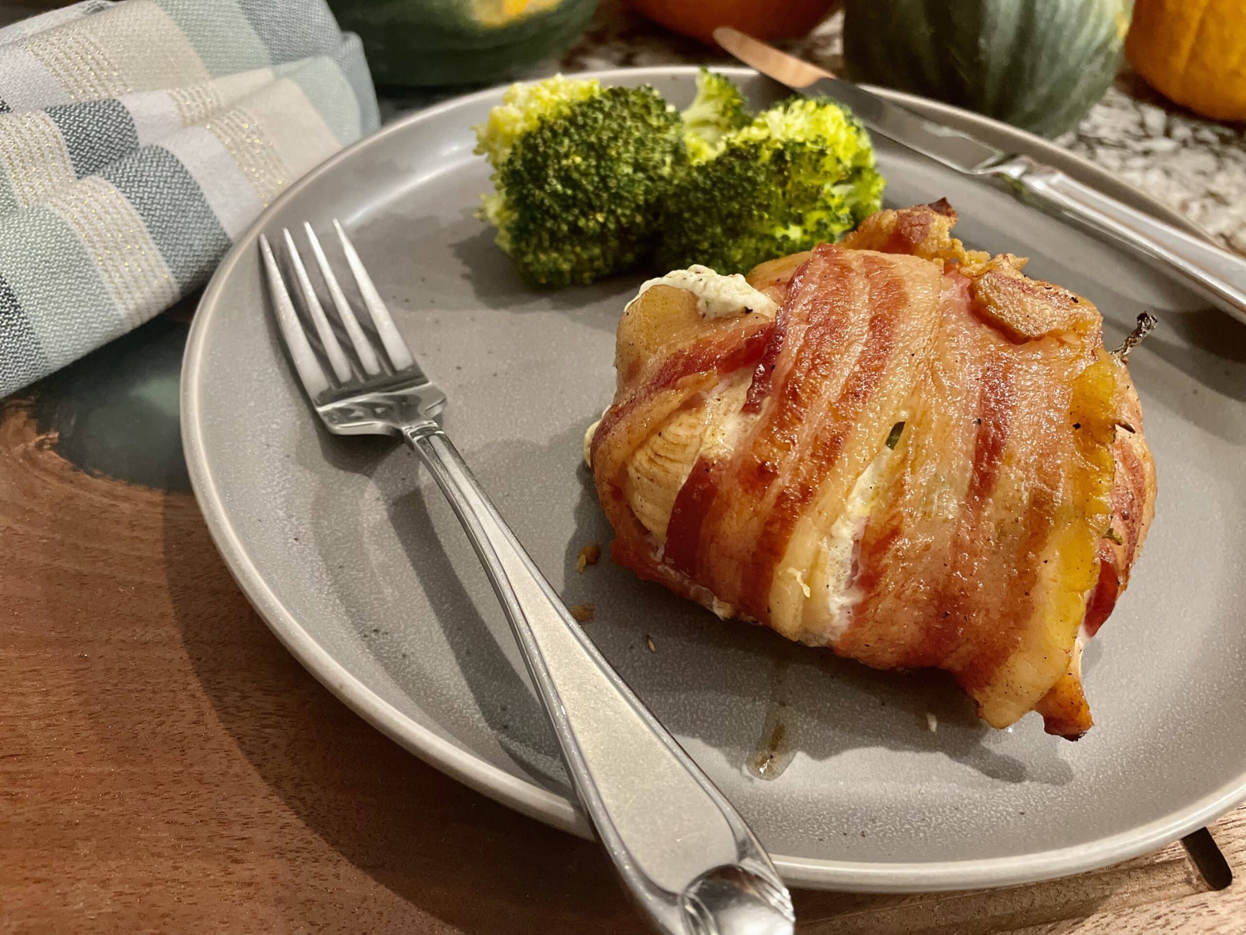 Stuffed tuscan chicken with broccoli on a gray plate with fork