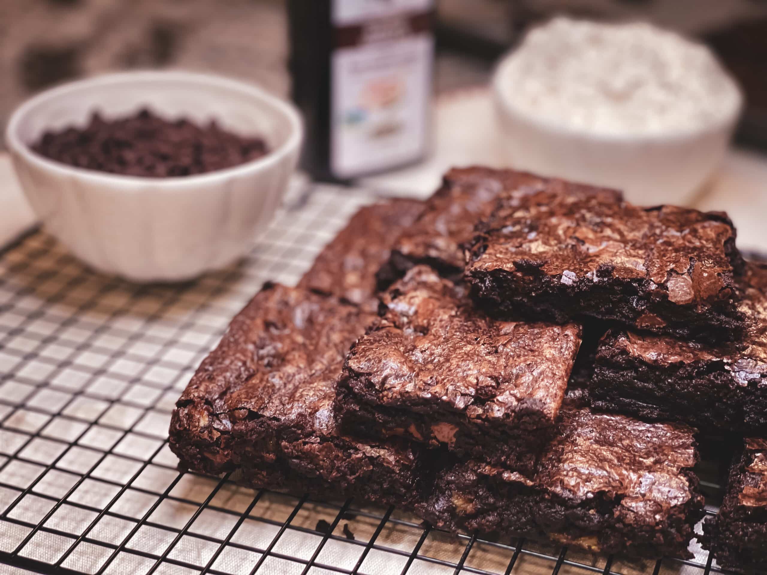 Stack of brownies on a plate with chocolate chips in background