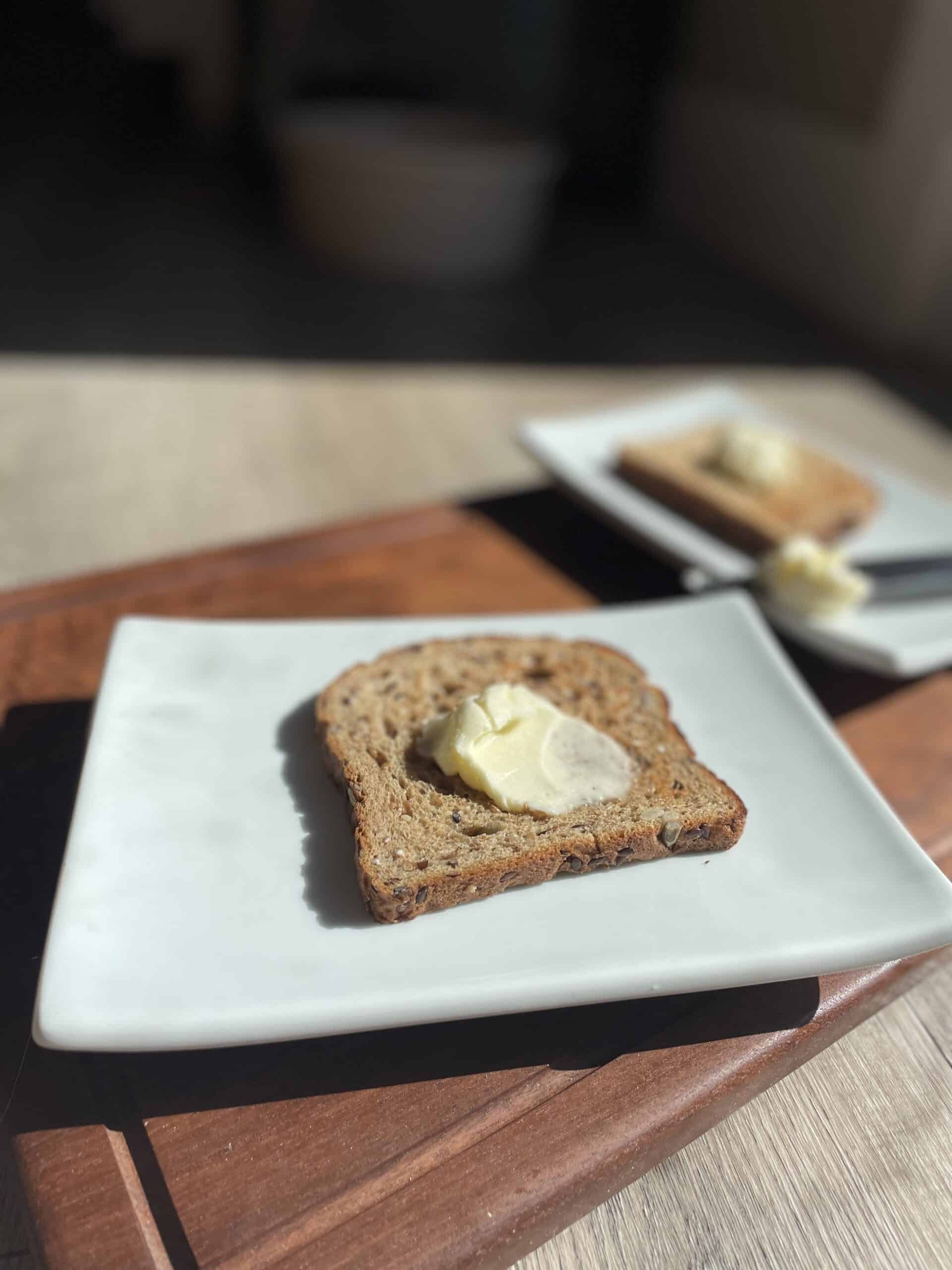 Butter on toast on white plate