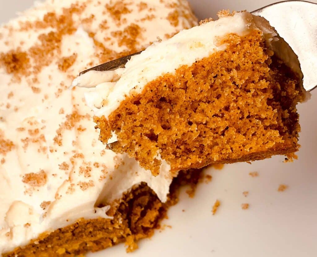 Fork with a Bite of Pumpkin Bar on It with Pumpkin Bare in the Background