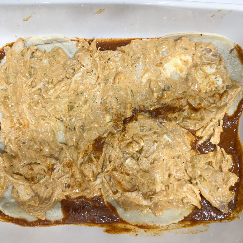 Adding Chicken and Cream Cheese Mixture to Chicken Enchiladas with Cream Cheese