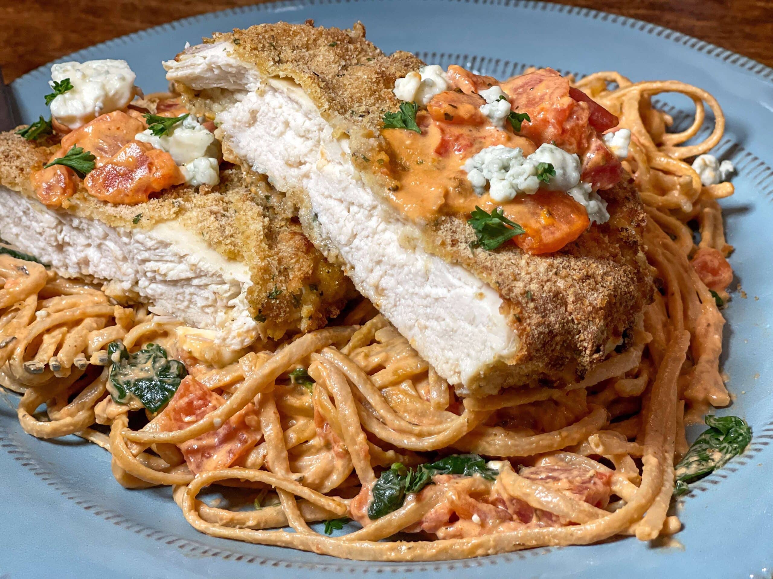Breaded chicken on top of tomato sauce covered linguini
