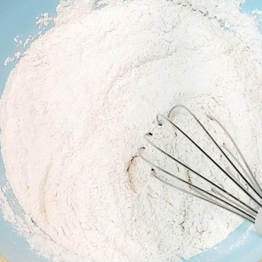 Banana Cake Dry Ingredients with Whisk in Blue Bowl
