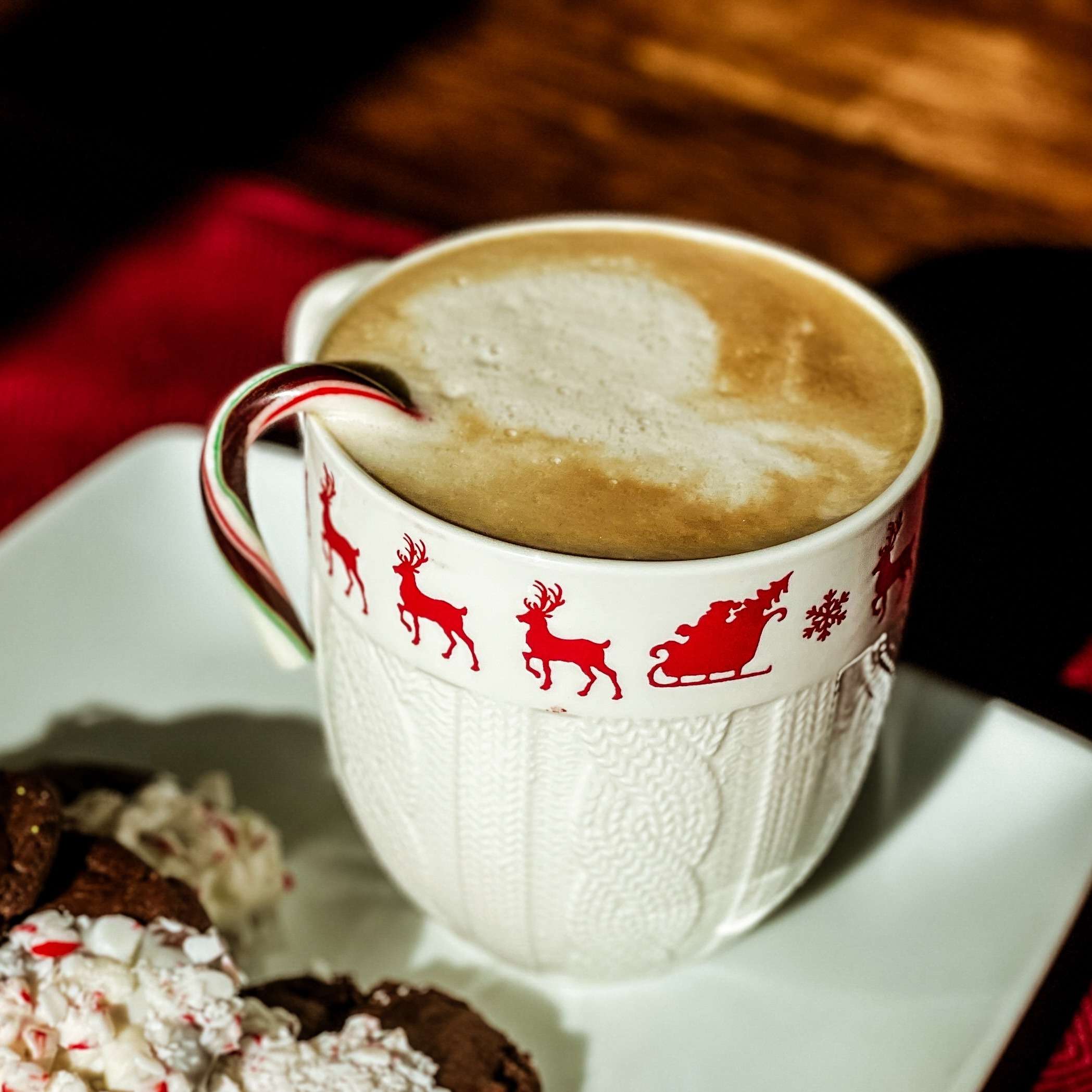 White Chocolate Peppermint Mocha Latte in a white cup with reindeer on it and candy cane