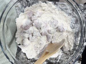 Stew Meat Coated in Flour for Beef Stew with Stew Meat in a Glass Bowl