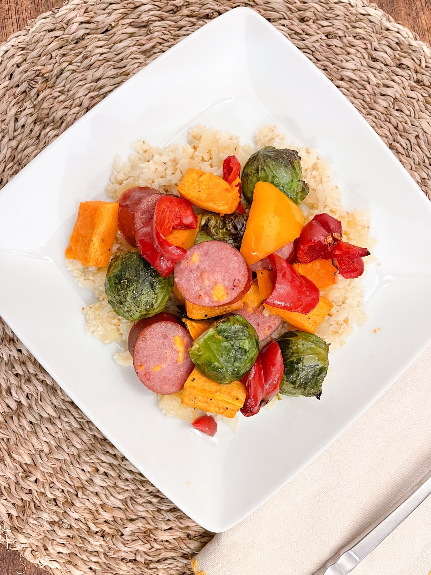 Hawaiian Maple Sausage & Veggies on a bed of cauliflour rice on a white plate