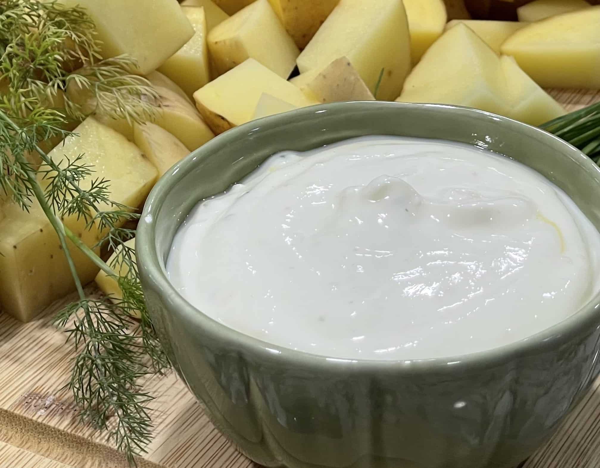 Greek Yogurt Mayonnaise In Greek bowl with potatoes