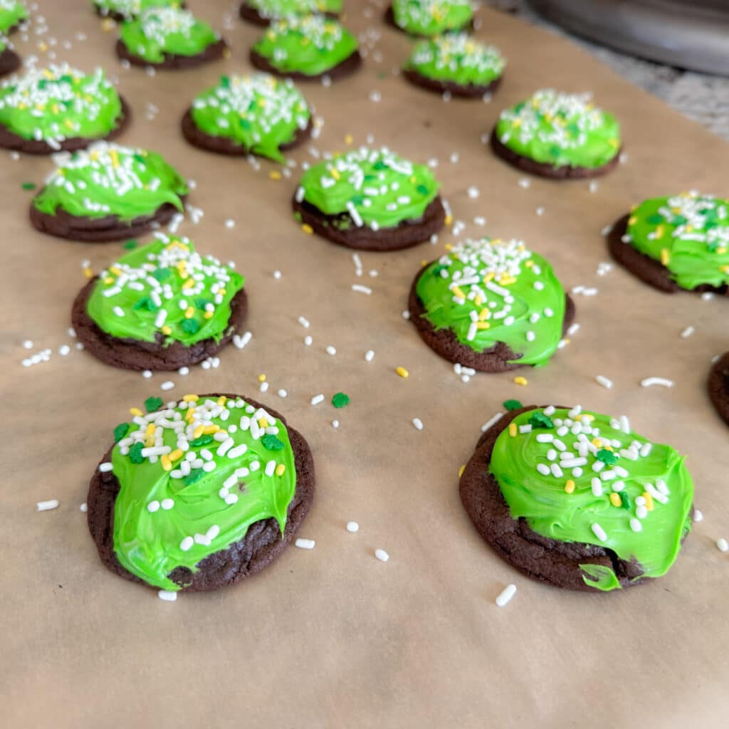 Green Icing and Sprinkles on Baked Dough Balls for Saint Patrick's Day Cookies