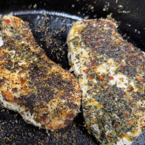 2 Chicken Breasts Fried in Cast Iron Skillet Covered in Greek Seasoning