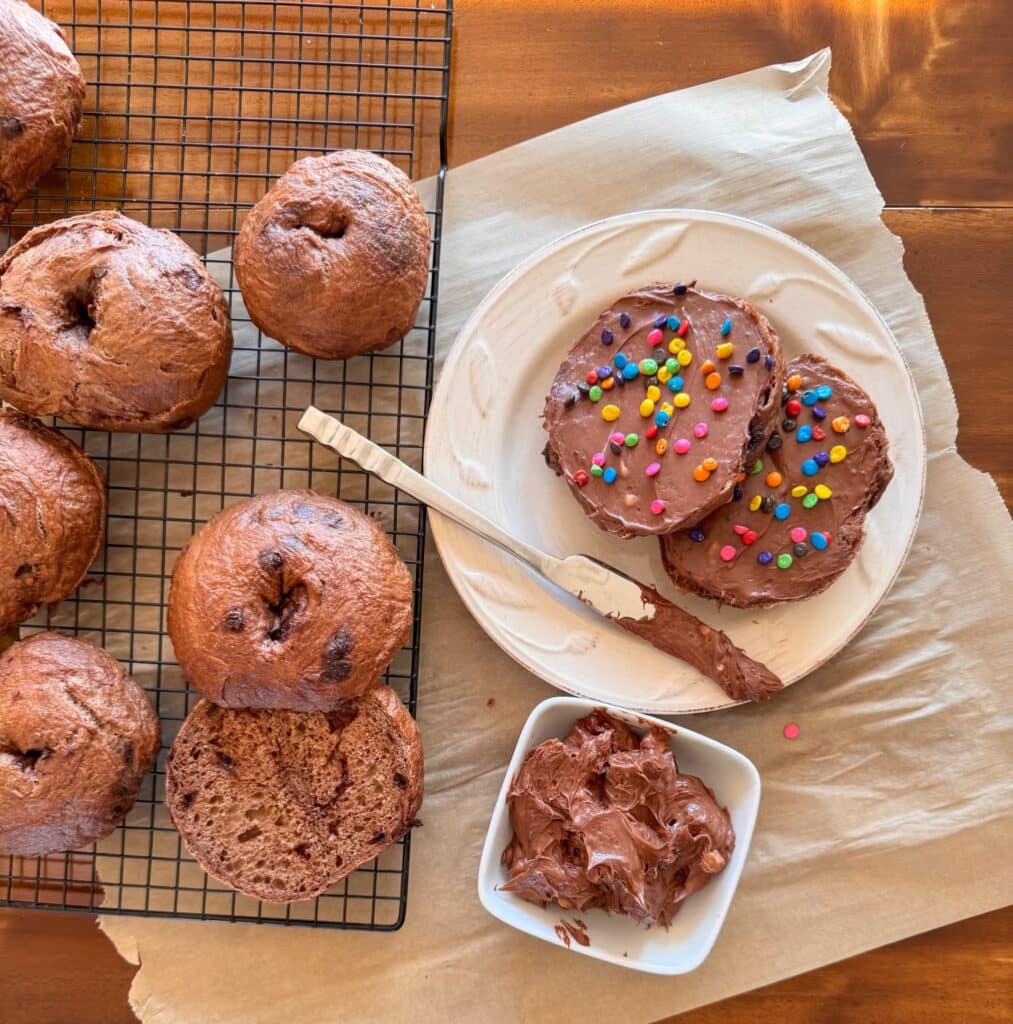 Pile of Cosmic Brownie Bagels, Sliced Cosmic Brownie Bagel and Chocolate Cream Cheese in a Small Bowl