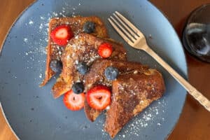 Overhead Shot of Slices of French Toast on a Blue Plate with Fruit