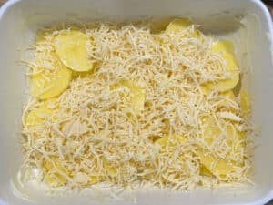 Layering Potatoes and Cheese for Au Gratin Potatoes in a Casserole Dish