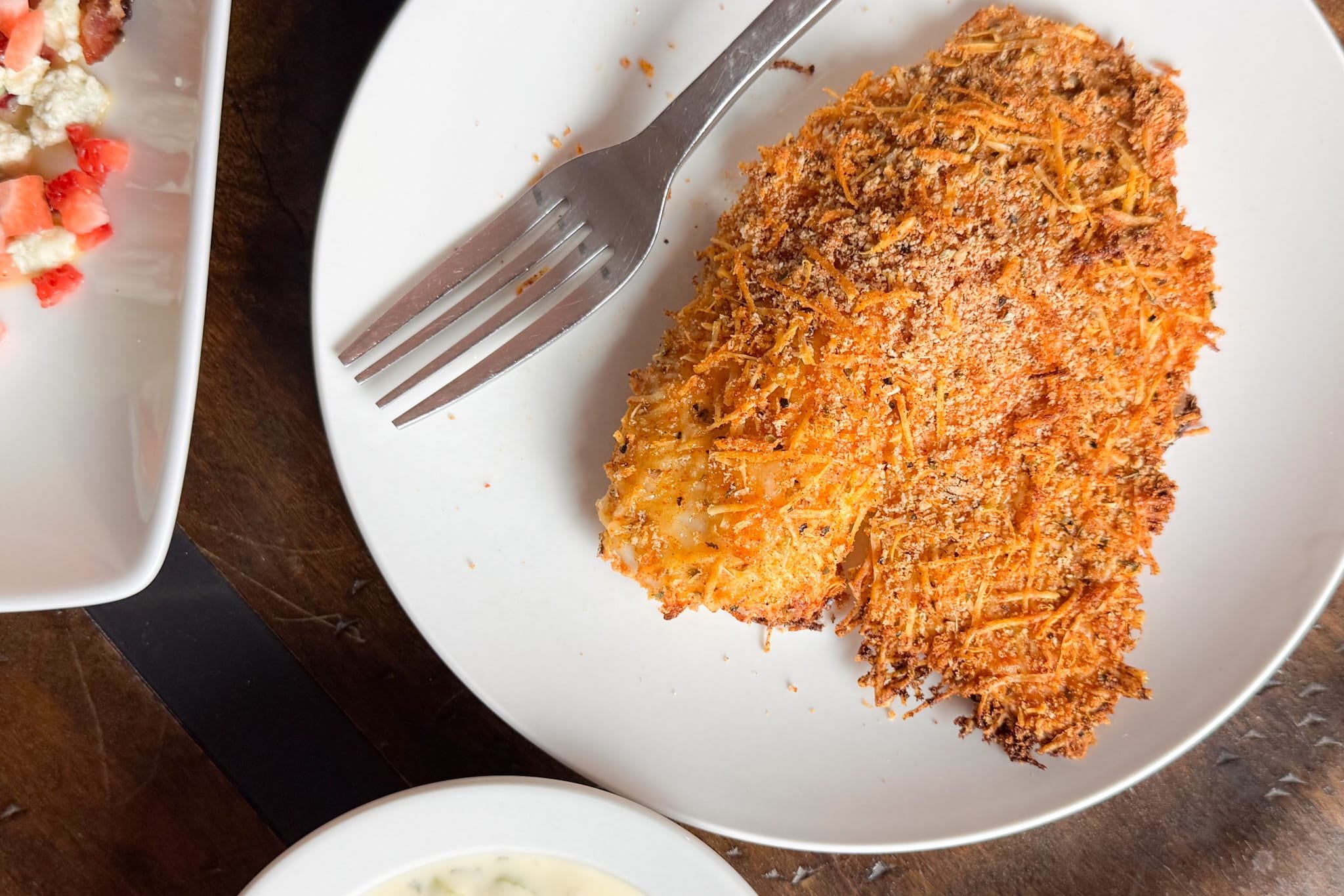 Parmesan Crusted Tilapia on white plate with fork