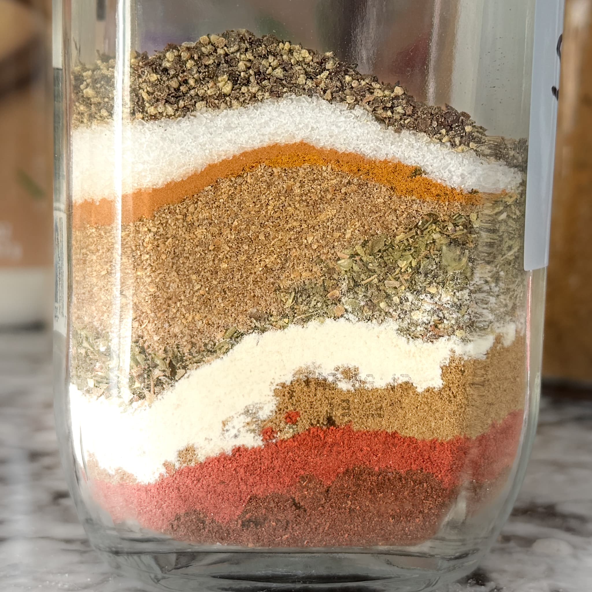 Layered ingredients in taco seasoning in a glass bottle