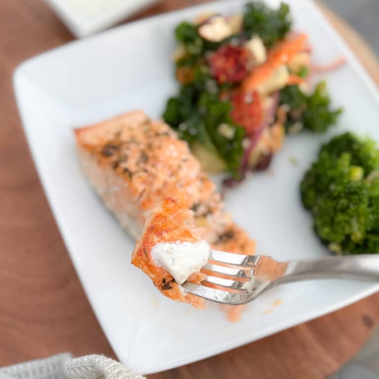 Forkful Lemon Garlic Baked Salmon on a Fork with Salmon in the Background