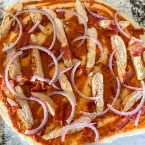 Pizza Sauce, Chicken and Red Onions on Pizza Dough