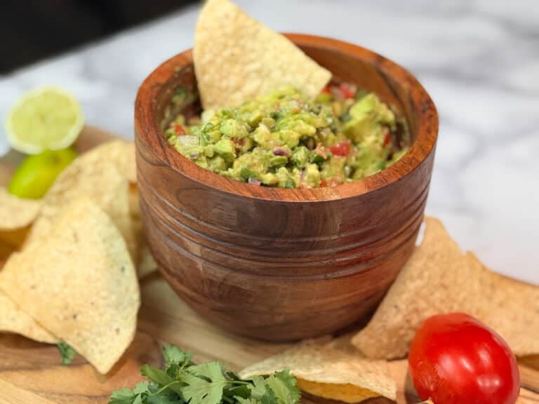 Chunky Guacamole in a Bowl with a Chip
