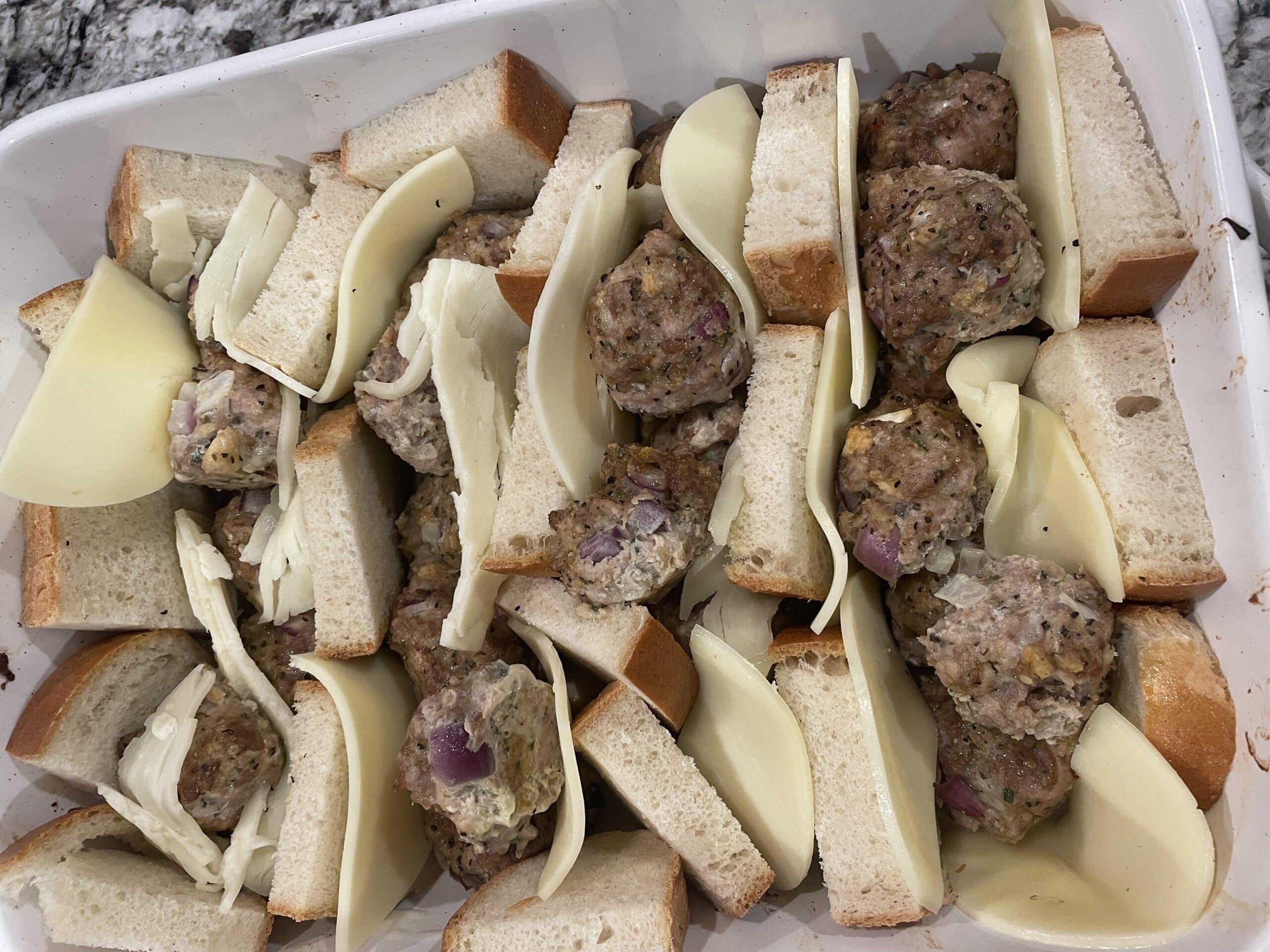 Tuck Italian Bread and Cheese Slices in Betweent He Rows of Meatballs.